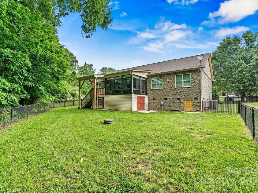 7020 Cedar Ridge Court, Mount Holly, NC 28120.  MLS# CAR4256213, YatesRealty ID 16957. The red door leads to enclosed storage underneath the Sunroom.  Not to mention, the crawlspace is fully encapsulated with a dehumidifier. Back yard is fenced, but there is still room to extend fencing, if desired.