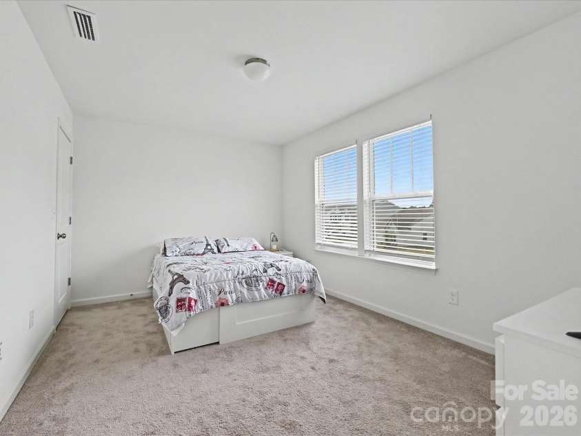 5125 Arbordale Way, Mount Holly, NC 28120.  MLS# CAR4353356, YatesRealty ID 17157. Bright secondary bedroom with plush carpeting, ample natural light, and a versatile layout ideal for guests or family.