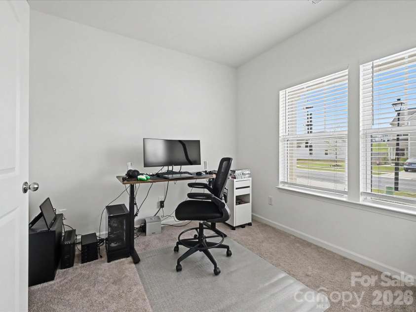 5125 Arbordale Way, Mount Holly, NC 28120.  MLS# CAR4353356, YatesRealty ID 17157. Light-filled home office with large windows, plush carpeting, and a functional layout perfect for remote work or study.
