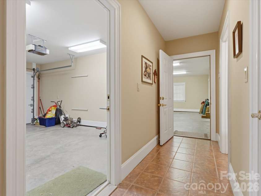 1215 Rosa Drive, Monroe, NC 28112.  MLS# CAR4366917, YatesRealty ID 17172. Hallway to garage spaces.  Single garage is heated/cooled. Half bath on right and additional storage closet right side.