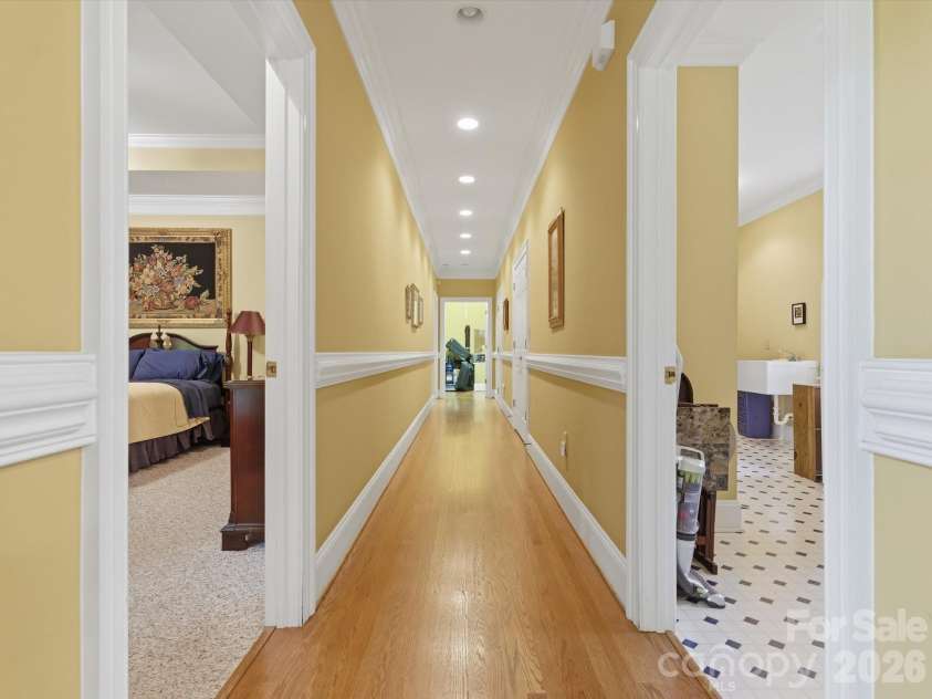1215 Rosa Drive, Monroe, NC 28112.  MLS# CAR4366917, YatesRealty ID 17172. Hallway to primary (left) and laundry room (right).  End of hallway storage with pull down stairs- originally designed for full staircase with access to additional space to build out a bonus space on upper level.