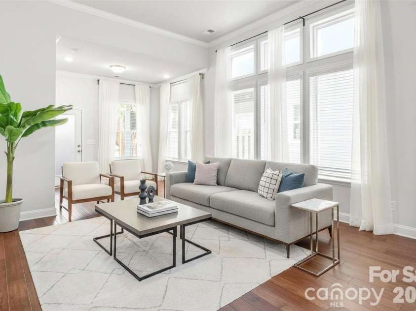 411 Belton Street, Charlotte, NC 28209.  MLS# CAR4321222, YatesRealty ID 17202. Dramatic living room with 10’ ceilings and tall windows create a bright, open space perfect for relaxing or entertaining. (Virtual Image)