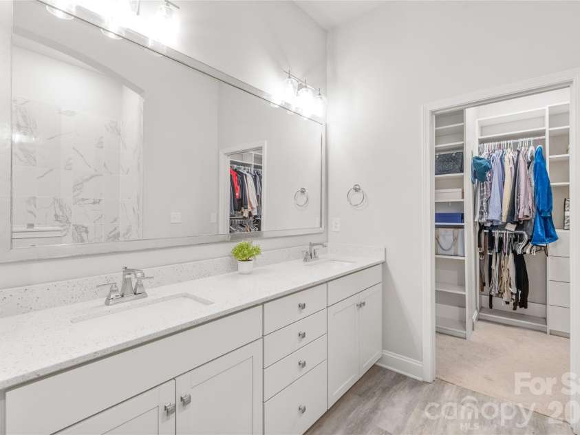 411 Belton Street, Charlotte, NC 28209.  MLS# CAR4321222, YatesRealty ID 17202. Luxury primary bath with dual sinks, a walk-in shower, and an expansive custom closet — your personal retreat awaits.