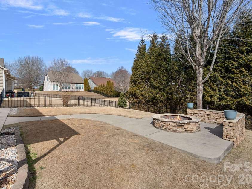 135 Rainberry Drive, Mooresville, NC 28117.  MLS# CAR4345698, YatesRealty ID 1721. Entertainer’s backyard with stunning hardscaping, fire pit, fenced yard, and ample seating