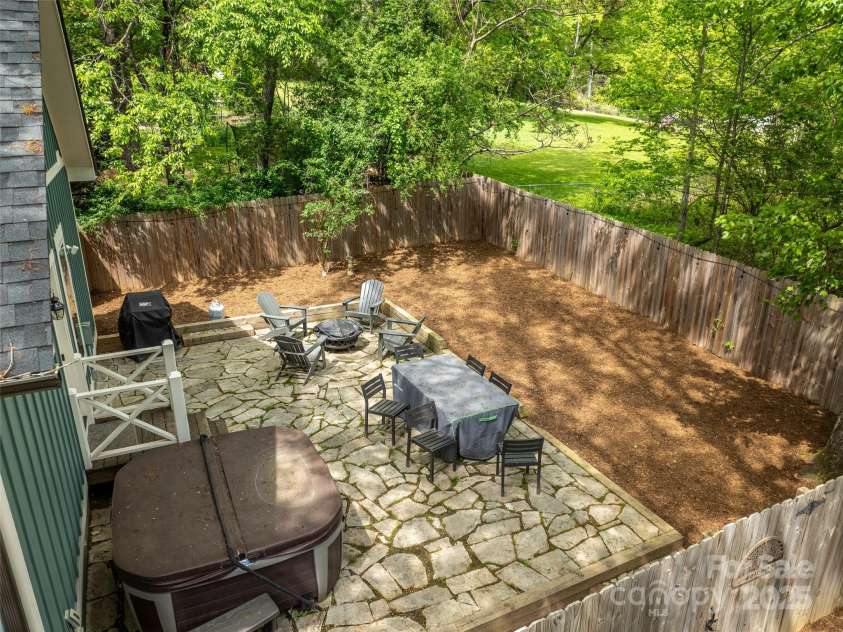 328 Mccoy Cove Road, Black Mountain, NC 28711.  MLS# CAR4248740, YatesRealty ID 17223. Fully fenced backyard with stone patio, gas grill, hot tub, firepit and dining table/chairs.
