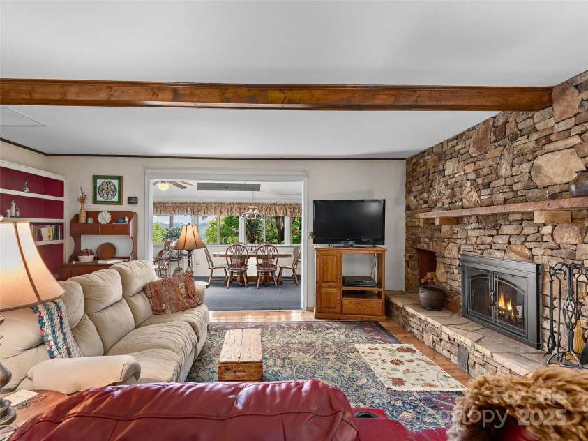 573 Valeria Lane, Pisgah Forest, NC 28768.  MLS# CAR4266219, YatesRealty ID 17256. Cozy living room with stone fireplace
