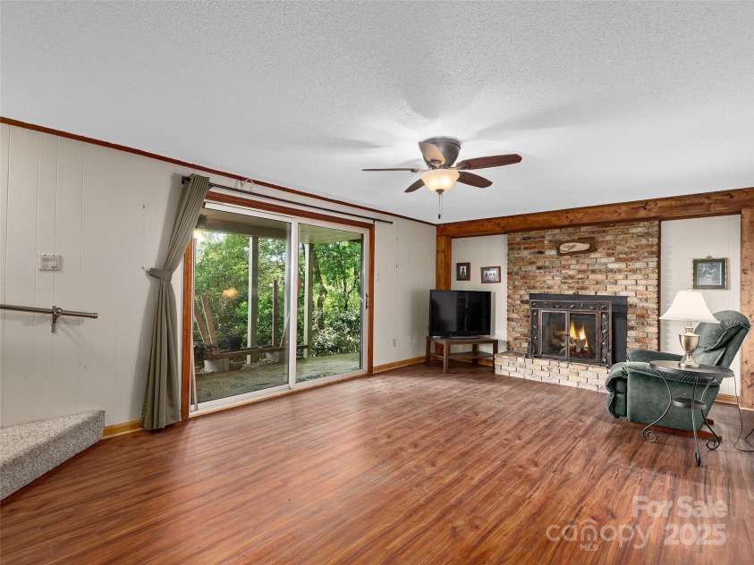 573 Valeria Lane, Pisgah Forest, NC 28768.  MLS# CAR4266219, YatesRealty ID 17256. Family room with fireplace