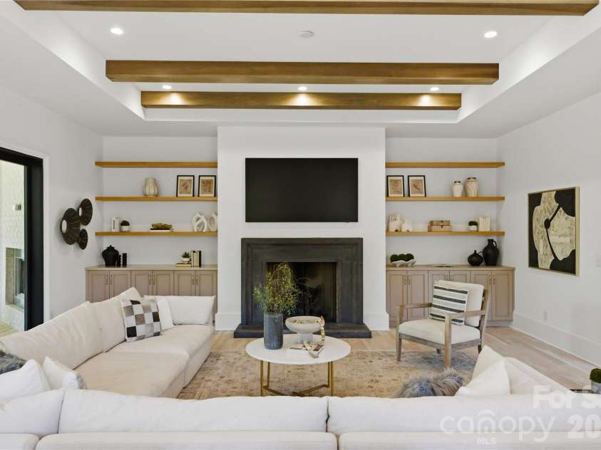7005 Chateau Bordeaux Lane, Charlotte, NC 28270.  MLS# CAR4361151, YatesRealty ID 17330. Statement fireplace wall with custom built-ins and clean architectural lines anchoring the main living space with warmth and sophistication.