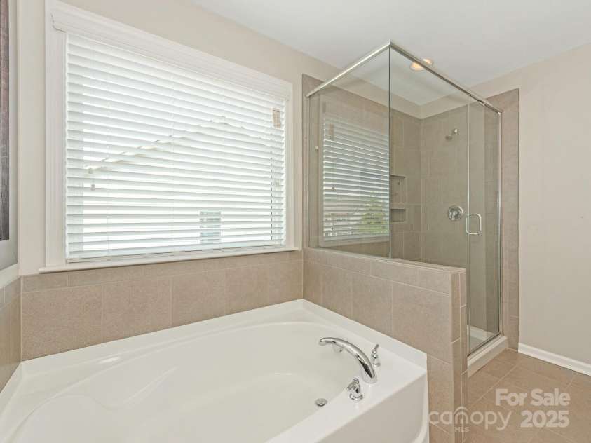 4912 Grace View Drive, Pineville, NC 28134.  MLS# CAR4261040, YatesRealty ID 17367. Garden tub and walk-in shower for the primary bedroom!