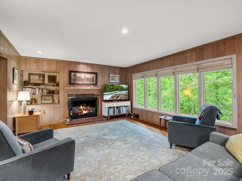 185 Greenstoke Loop, Tryon, NC 28782.  MLS# CAR4261125, YatesRealty ID 17387. Living room with wood burning fireplace and wormy chestnut paneling