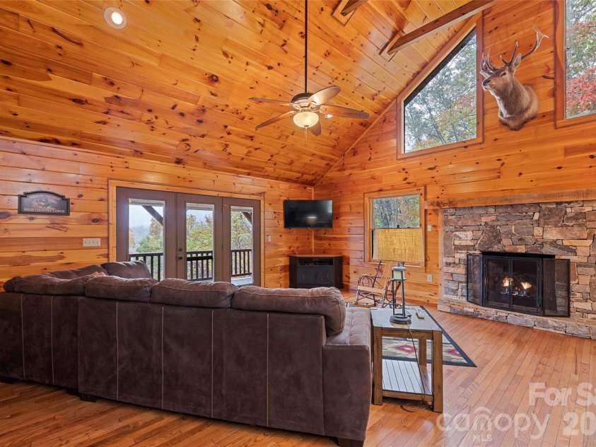 235 Soaring Eagle Road, Bryson City, NC 28713.  MLS# CAR4316418, YatesRealty ID 1739. Native stone fireplace with gas logs, gable windows for natural light and included media center (taxidermy does not convey) 