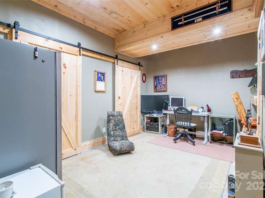 58 Great Aspen Way, Black Mountain, NC 28711.  MLS# CAR4256095, YatesRealty ID 17415. Flex room in the basement offers storage behind the barn doors.
