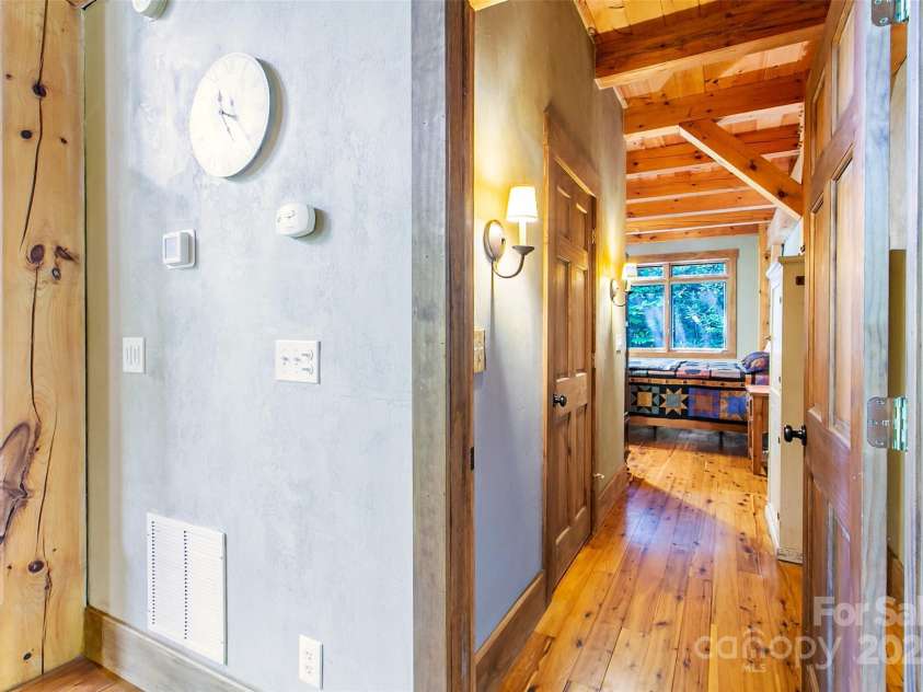 58 Great Aspen Way, Black Mountain, NC 28711.  MLS# CAR4256095, YatesRealty ID 17415. Looking down the hall into the ensuite primary bedroom. The door to the walk-in closet is pictured on the left.