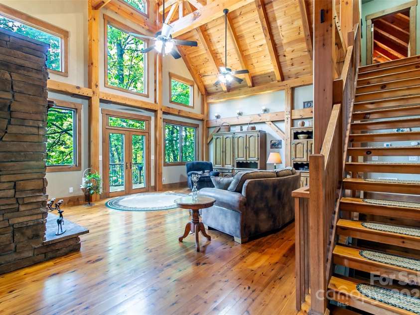 58 Great Aspen Way, Black Mountain, NC 28711.  MLS# CAR4256095, YatesRealty ID 17415. Looking from the foyer into the light-filled living room with its wood-burning fireplace and vaulted ceiling.
