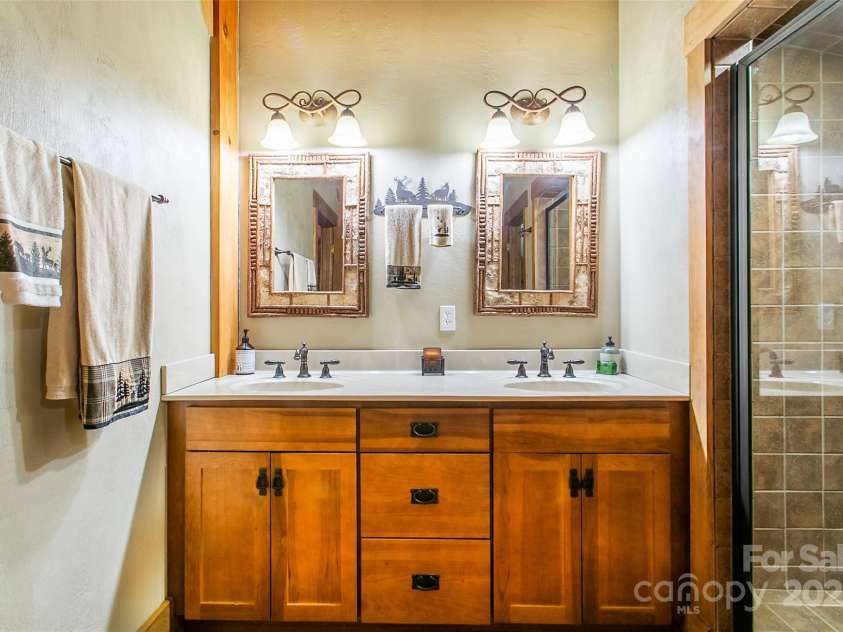 58 Great Aspen Way, Black Mountain, NC 28711.  MLS# CAR4256095, YatesRealty ID 17415. Twin vanities in the loft bathroom. Note the large fully tiled shower on the right with sitting bench.