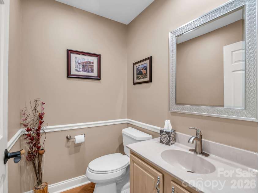 59 Agaliha Lane, Brevard, NC 28712.  MLS# CAR4392248, YatesRealty ID 1745. A charming half-bath is conveniently located on the main level for guests, featuring elegant trim and neutral tones.