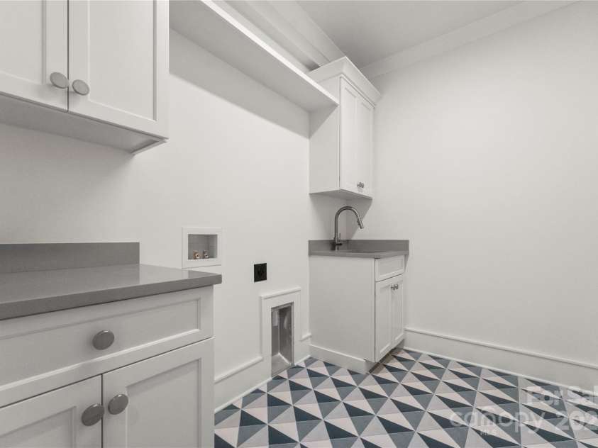 4142 Pineview Road, Charlotte, NC 28211.  MLS# CAR4127542, YatesRealty ID 17466. Tiled floor in laundry with sink & cabinets