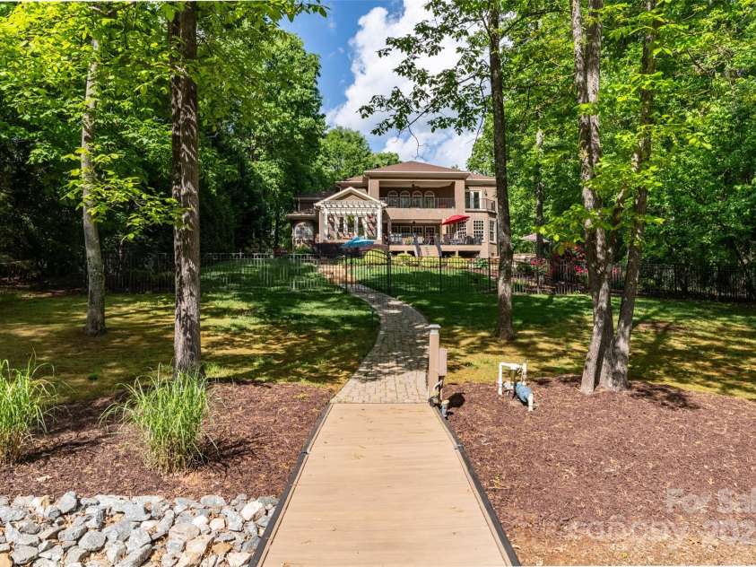 135 Sumter Drive, Mooresville, NC 28117.  MLS# CAR4252213, YatesRealty ID 17490. Meticulously designed and maintained, this private retreat sits between the heavily treed neighborhood access lot on the left and a 10 acres tract with protected shoreline on the right.