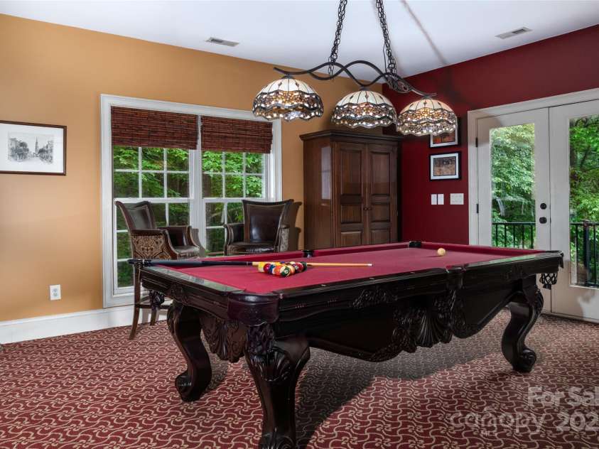 135 Sumter Drive, Mooresville, NC 28117.  MLS# CAR4252213, YatesRealty ID 17490. The Billiard Room overlooks the great-room and provides access to the veranda overlooking the private backyard, pool and lake.