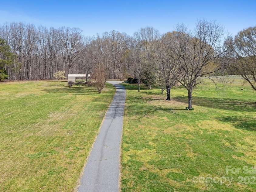 1235 Wilma Sigmon Road, Lincolnton, NC 28092.  MLS# CAR4238963, YatesRealty ID 17591. The house sits far off of the road with a tree-lined, paved driveway.