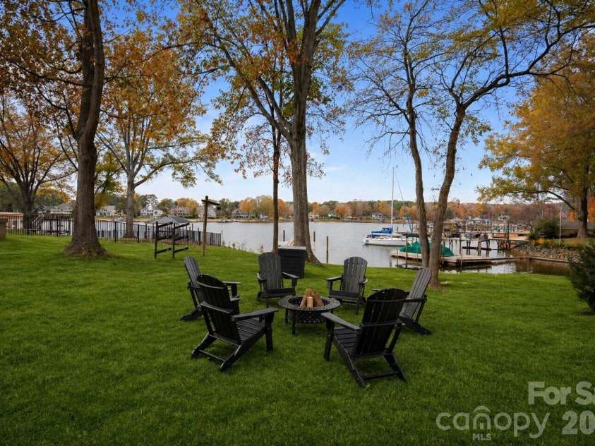 240 Shoreline Loop, Mooresville, NC 28117.  MLS# CAR4375040, YatesRealty ID 17619. Lakeside fire pit area surrounded by mature trees offering a private setting for entertaining and enjoying waterfront evenings