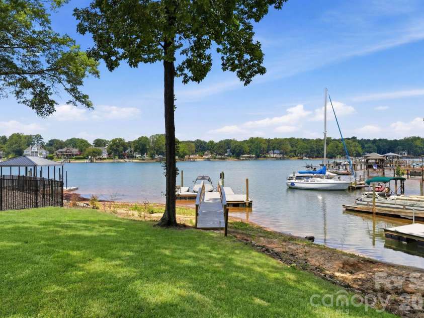 240 Shoreline Loop, Mooresville, NC 28117.  MLS# CAR4375040, YatesRealty ID 17619. Spacious backyard with mature trees and gentle slope to the water offering privacy open space and beautiful lake views