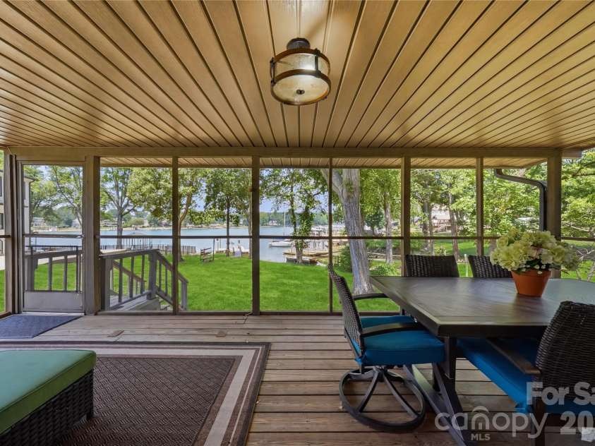 240 Shoreline Loop, Mooresville, NC 28117.  MLS# CAR4375040, YatesRealty ID 17619. Spacious screened porch with dining and grilling area overlooking a peaceful backyard with water views. Perfect for entertaining or enjoying lake weekends.