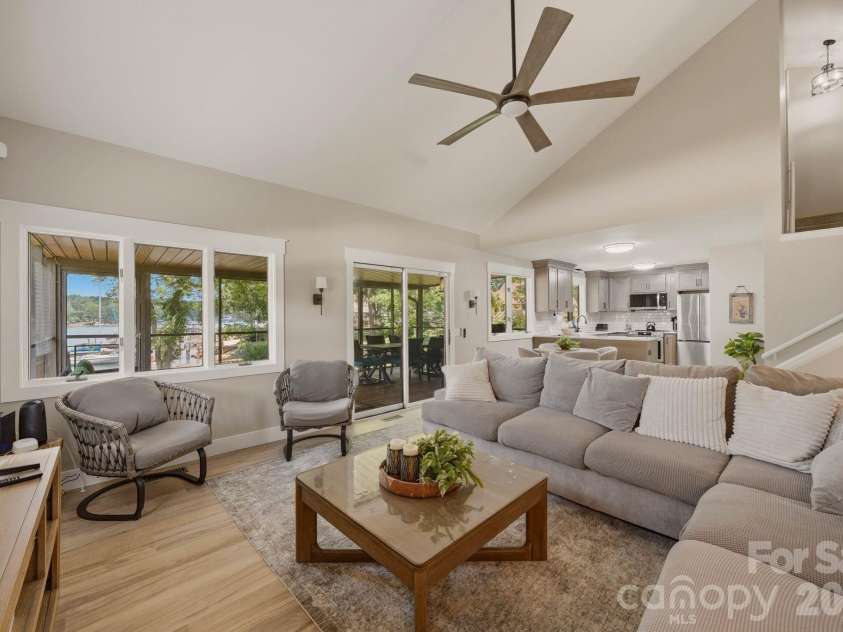 240 Shoreline Loop, Mooresville, NC 28117.  MLS# CAR4375040, YatesRealty ID 17619. Stunning Lake Norman waterfront living room with vaulted ceilings, abundant natural light, and panoramic water views