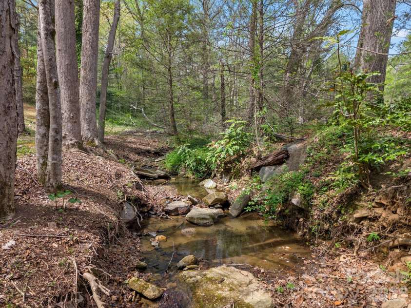140 Meadowlark Drive, Tryon, NC 28782.  MLS# CAR4364731, YatesRealty ID 17628. Creek along rear boundary line.