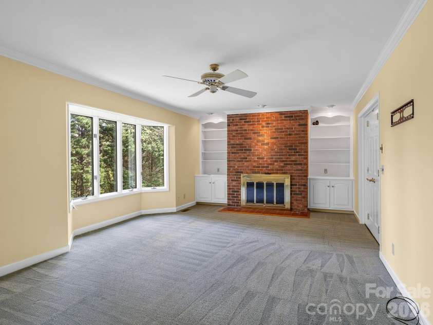 140 Meadowlark Drive, Tryon, NC 28782.  MLS# CAR4364731, YatesRealty ID 17628. Den on main level with gas log FP & built-ins.
