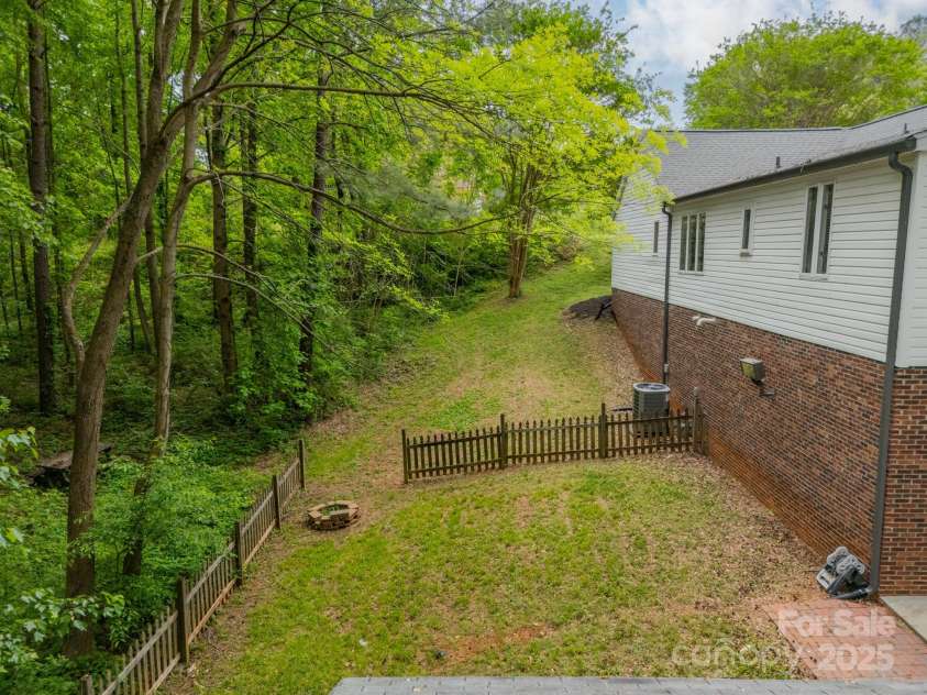 2646 Jacobs Road, Gastonia, NC 28054.  MLS# CAR4245565, YatesRealty ID 17641. Side of home adjacent to lot the empty wooded lot
