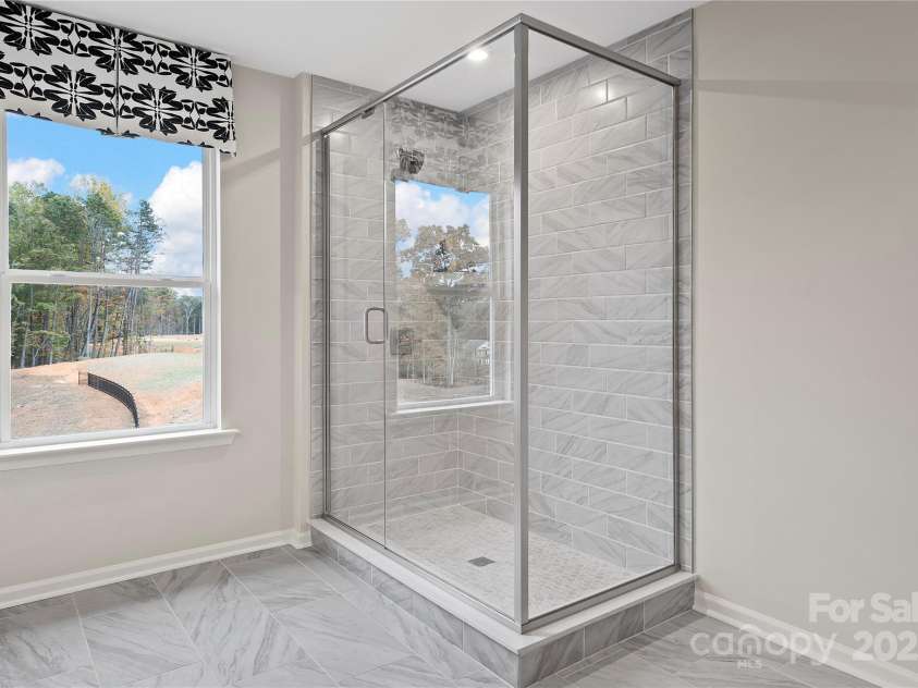 7101 Short Stirrup Lane, Mint Hill, NC 28227.  MLS# CAR4264118, YatesRealty ID 17710. This glass framed walk-in shower defines luxury. *actual finishes, structural selections, and orientation may vary.