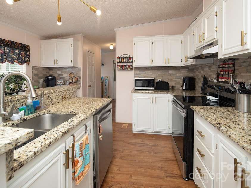 115 Tradewinds Court, Mooresville, NC 28115.  MLS# CAR4215397, YatesRealty ID 1774. Kitchen features granite counter tops and custom marble backsplash.
