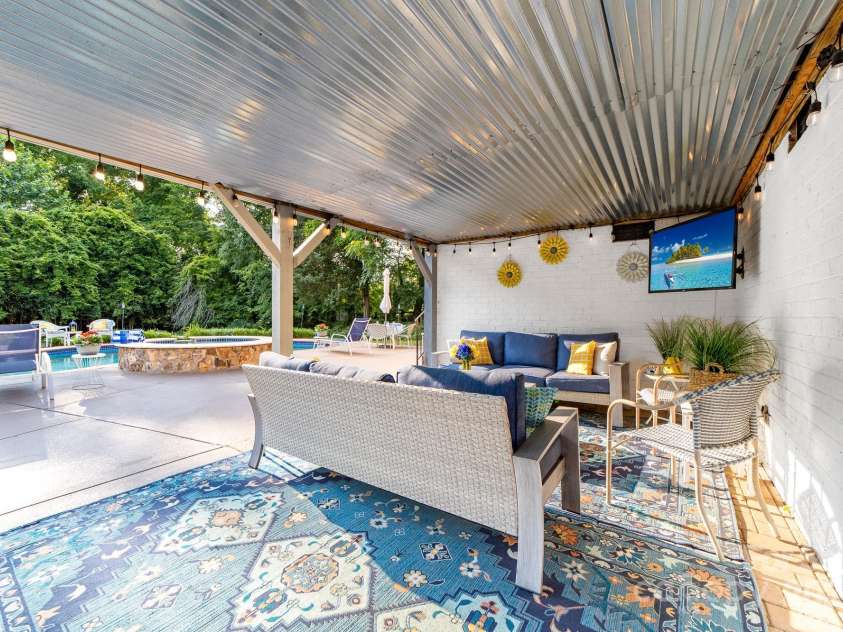 1115 Maremont Court, Matthews, NC 28104.  MLS# CAR4265008, YatesRealty ID 17750. Covered lower level patio with outdoor TV. Patio area connects to the grilling area.