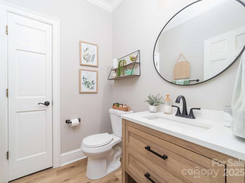 1115 Maremont Court, Matthews, NC 28104.  MLS# CAR4265008, YatesRealty ID 17750. Half bathroom on main level with linen closet.  Newly installed LVP flooring, bathroom vanity and fixtures.  Hardwood floors remain under the LVP flooring.