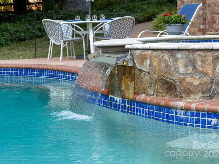 1115 Maremont Court, Matthews, NC 28104.  MLS# CAR4265008, YatesRealty ID 17750. Waterfall from the hot tub into the pool.