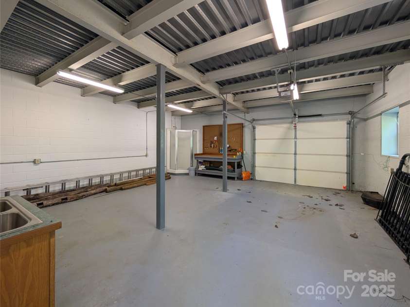355 Rosewood Lane, Burnsville, NC 28714.  MLS# CAR4326302, YatesRealty ID 17755. Inside the lower level one-car garage that would also make a great studio, workshop etc. There's also a shower & sink!