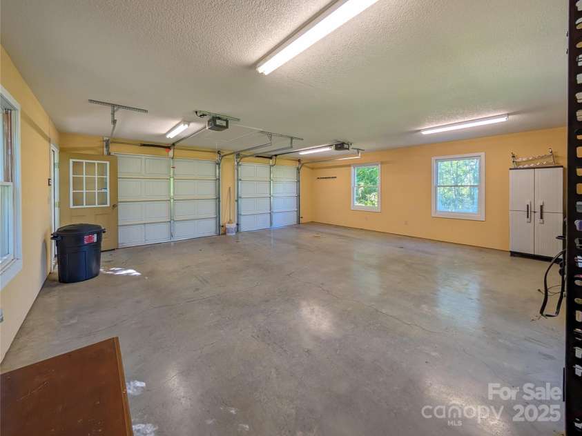 355 Rosewood Lane, Burnsville, NC 28714.  MLS# CAR4326302, YatesRealty ID 17755. Inside the Main level spacious 2-car garage that also has pull-down storage for extra space! 