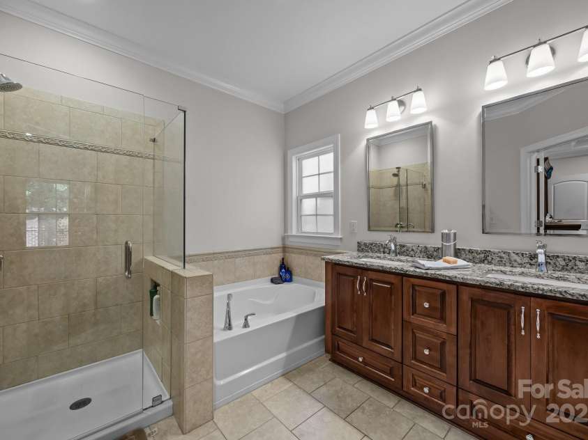 4004 Saint Andrews Court, Cramerton, NC 28032.  MLS# CAR4265985, YatesRealty ID 17805. Glass enclosed tile shower, soaking tub, double granite vanity