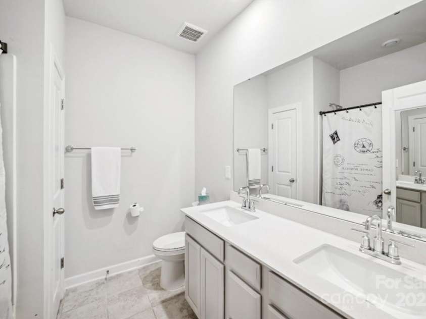 9525 Festival Way, Charlotte, NC 28215.  MLS# CAR4263190, YatesRealty ID 17807. Main level guest bath with dual sinks, bathtub, and linen cloest.