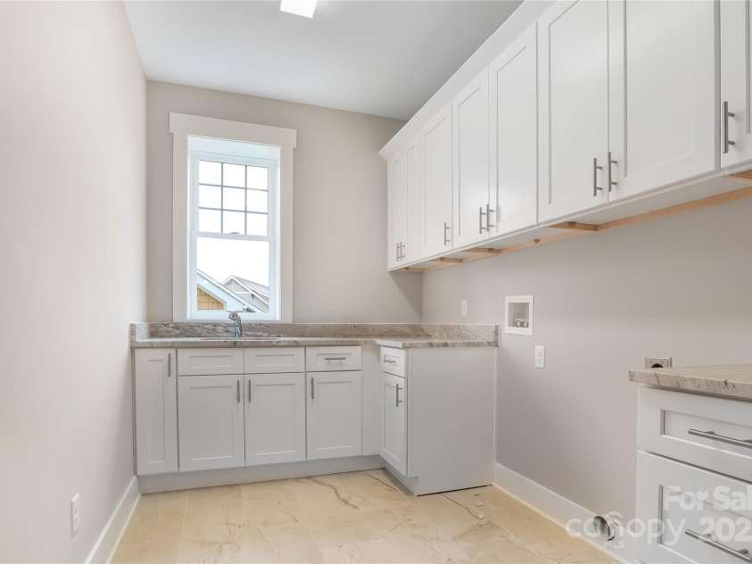 48 Creekside View Drive, Asheville, NC 28804.  MLS# CAR4046496, YatesRealty ID 17815. Huge laundry room with large tile floors, granite countertops and lots of cabinets for storage. Electric dryer connection and sink.