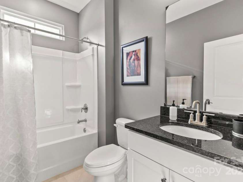 329 Secretariat Drive, Iron Station, NC 28080.  MLS# CAR4253728, YatesRealty ID 17822. Bath 2 features a tub shower enclosure, white vanity, tile flooring and transom window for natural light