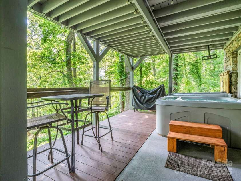 195 White Pine Drive, Lake Lure, NC 28746.  MLS# CAR4266532, YatesRealty ID 17828. Covered back patio & hot tub is accessible from the lower-level family room door.