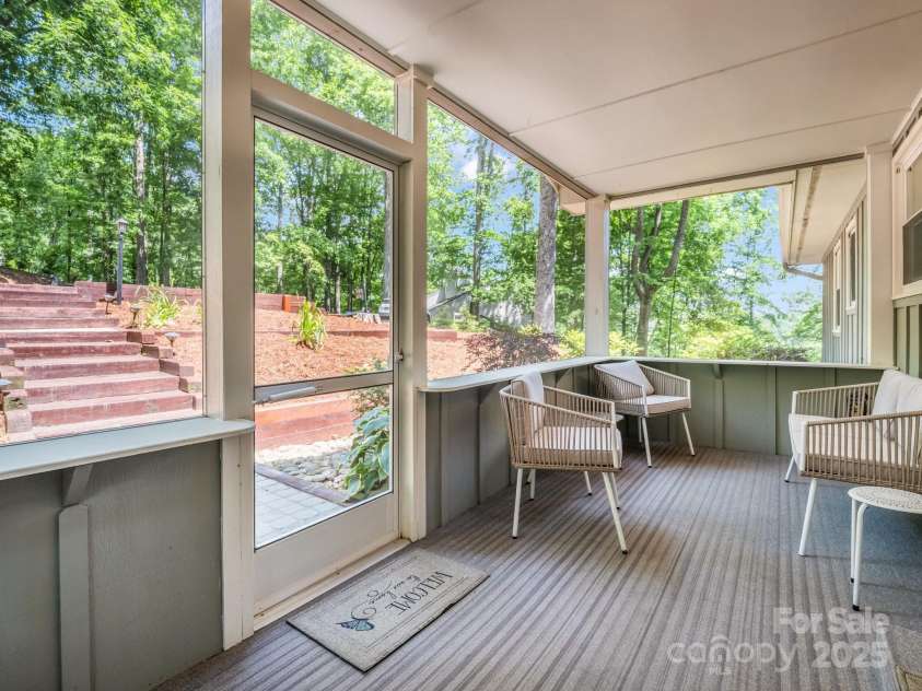 195 White Pine Drive, Lake Lure, NC 28746.  MLS# CAR4266532, YatesRealty ID 17828. Covered screen porch at the front door, just steps away from the upper-level parking area. Additional parking available in the 1-car oversized garage and lower level driveway.