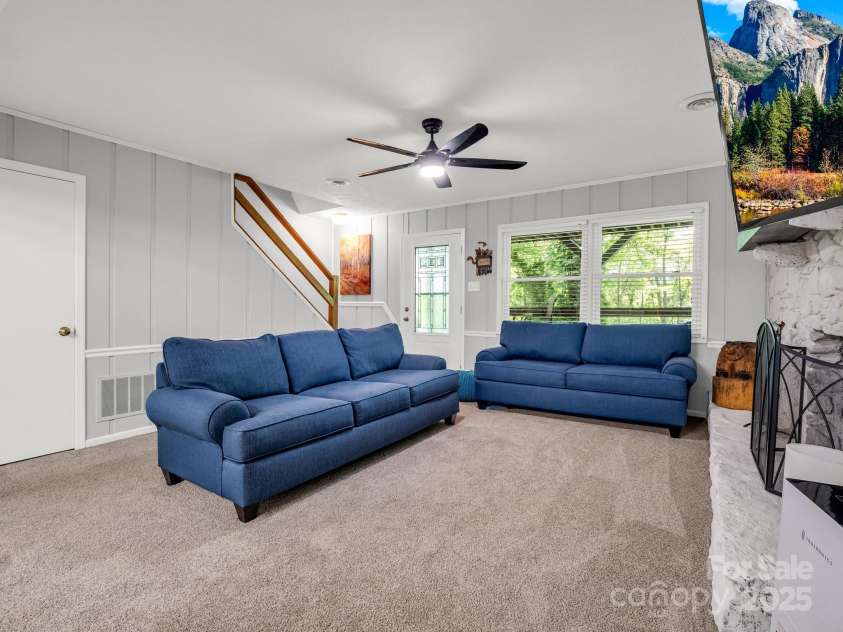 195 White Pine Drive, Lake Lure, NC 28746.  MLS# CAR4266532, YatesRealty ID 17828. Lower level in the finished walk-out basement boasts a stone fireplace, storage closet under the stairs, and access to the 1-car oversized garage.