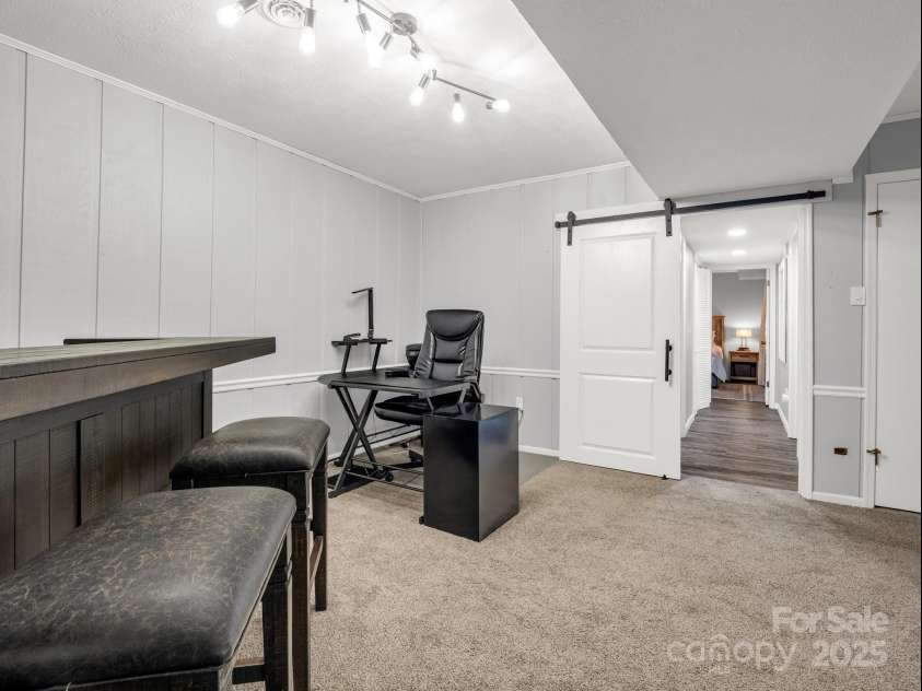 195 White Pine Drive, Lake Lure, NC 28746.  MLS# CAR4266532, YatesRealty ID 17828. Lower level in the finished walk-out basement boasts a stone fireplace, storage closet under the stairs.