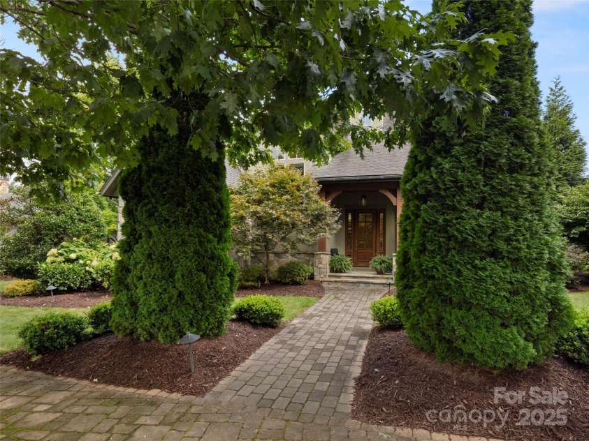 62 Running Creek Trail, Arden, NC 28704.  MLS# CAR4299725, YatesRealty ID 1785. Front view from sidewalk with landscape lighting that lights the path and entry in the evening.