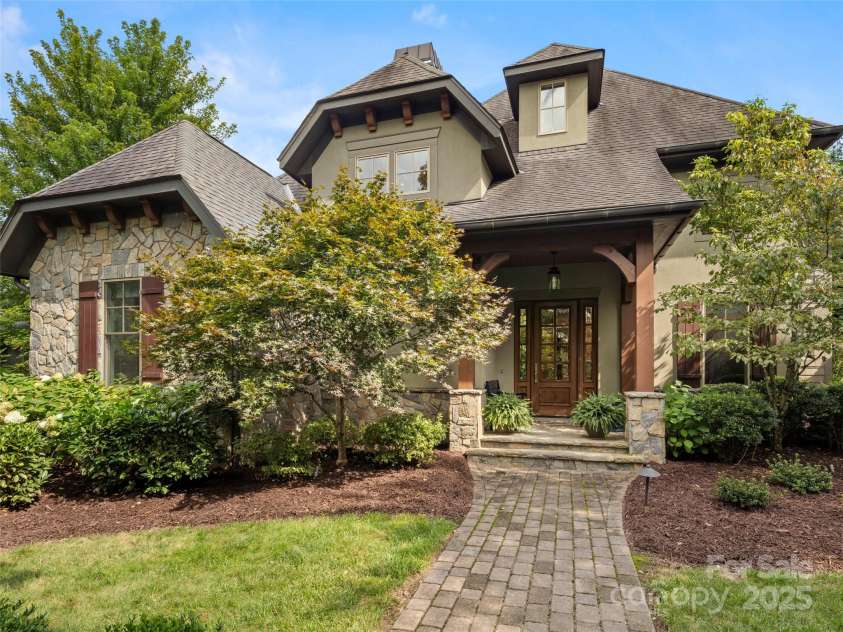 62 Running Creek Trail, Arden, NC 28704.  MLS# CAR4299725, YatesRealty ID 1785. Paver sidewalk leading to front door. Established landscaping features four season interest with specimen trees, lush bushes and perennial plantings with low maintenance requirements. 