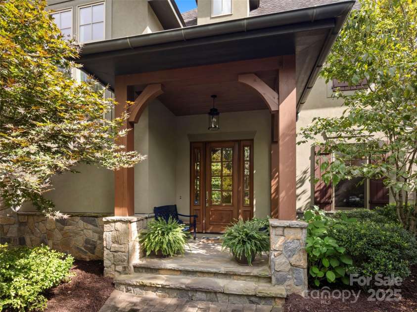 62 Running Creek Trail, Arden, NC 28704.  MLS# CAR4299725, YatesRealty ID 1785. Welcome home - lovely landscaping, stone steps and wooden beams create a pleasing, protected front entry with room for a bench.  Beautiful specimen trees (maple on the left, dogwood on the right) offer year-round interes