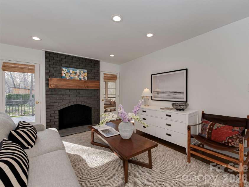 7244 Terrace Drive, Charlotte, NC 28211.  MLS# CAR4357695, YatesRealty ID 17887. Bask in the light of this beautiful living room, featuring recessed lighting, a wood-burning fireplace, and easy access to both the enclosed porch and the outdoor deck.